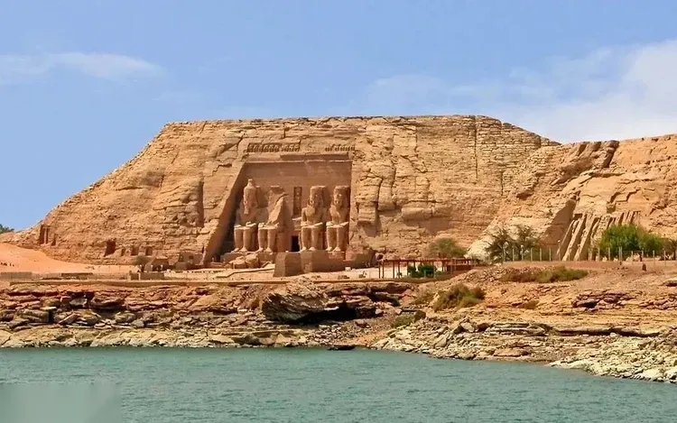 Close-up of the four colossal seated statues of Ramses II on the sandstone facade of the Great Temple.