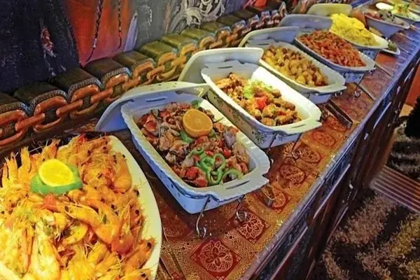 A buffet spread of shrimp and mixed seafood dishes laid out on a boat's dining table.