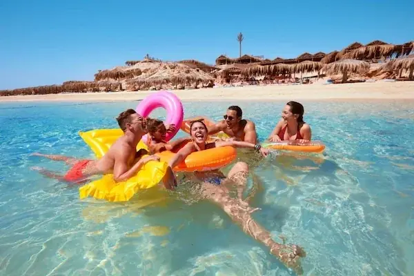 The gold-hulled yacht My Sky floating at anchor in turquoise water near a sandy Red Sea island.