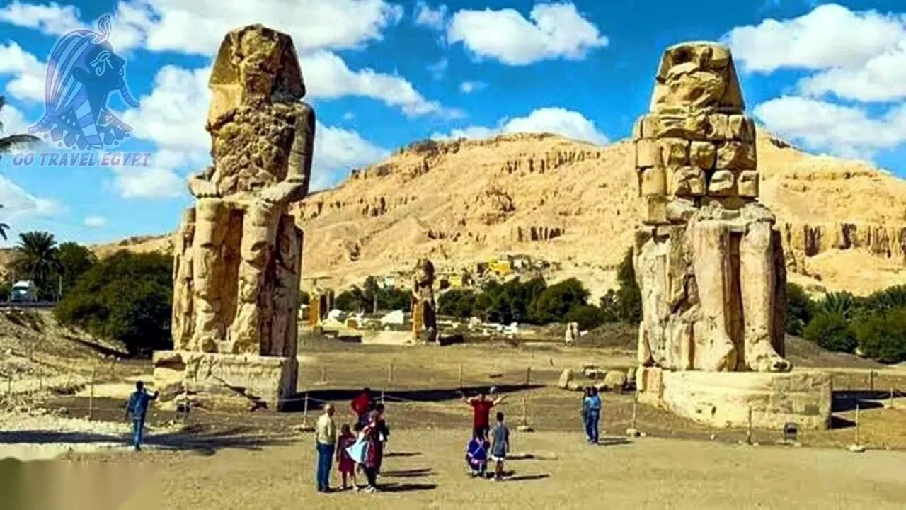 Stone pathway leads to the imposing facade of Dendera Temple with rows of Hathor-headed columns.