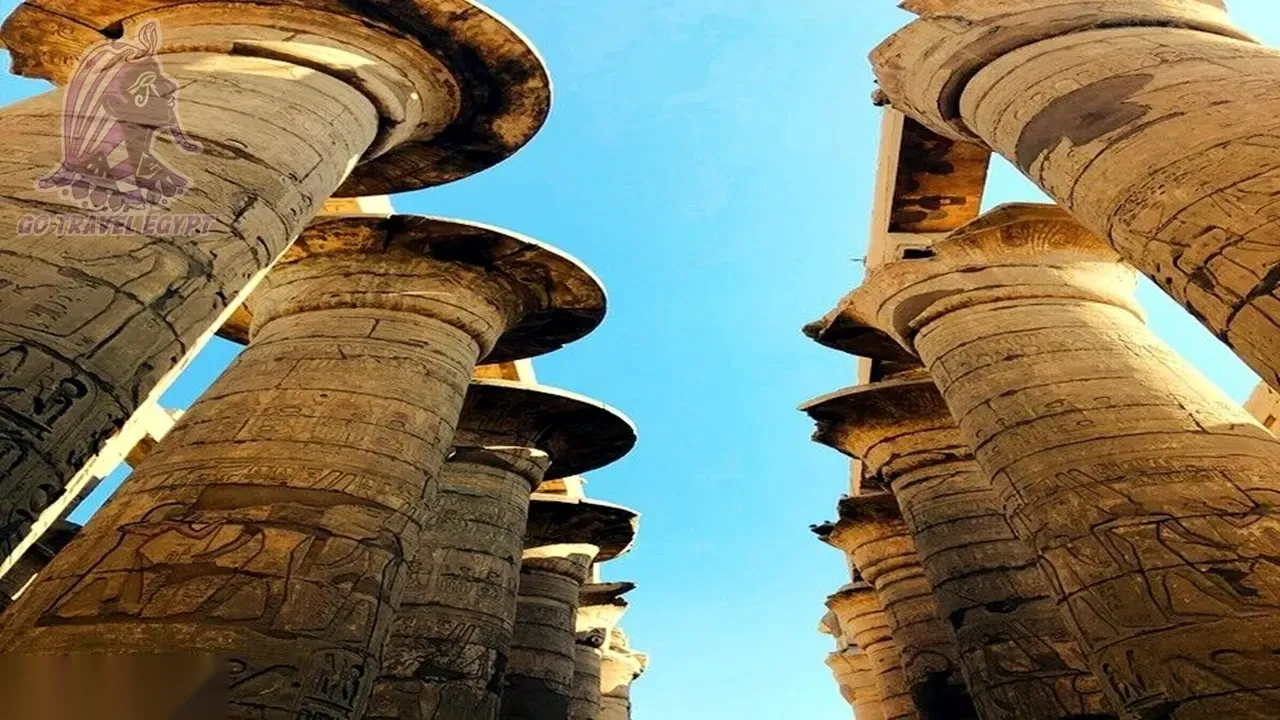 Close-up of carved stone columns topped with Hathor-head capitals along the temple's front wall.
