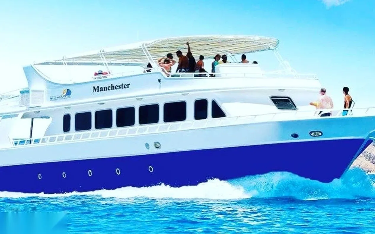 Excursion boat named Manchester with passengers on the upper deck, shown in heavily saturated colors.