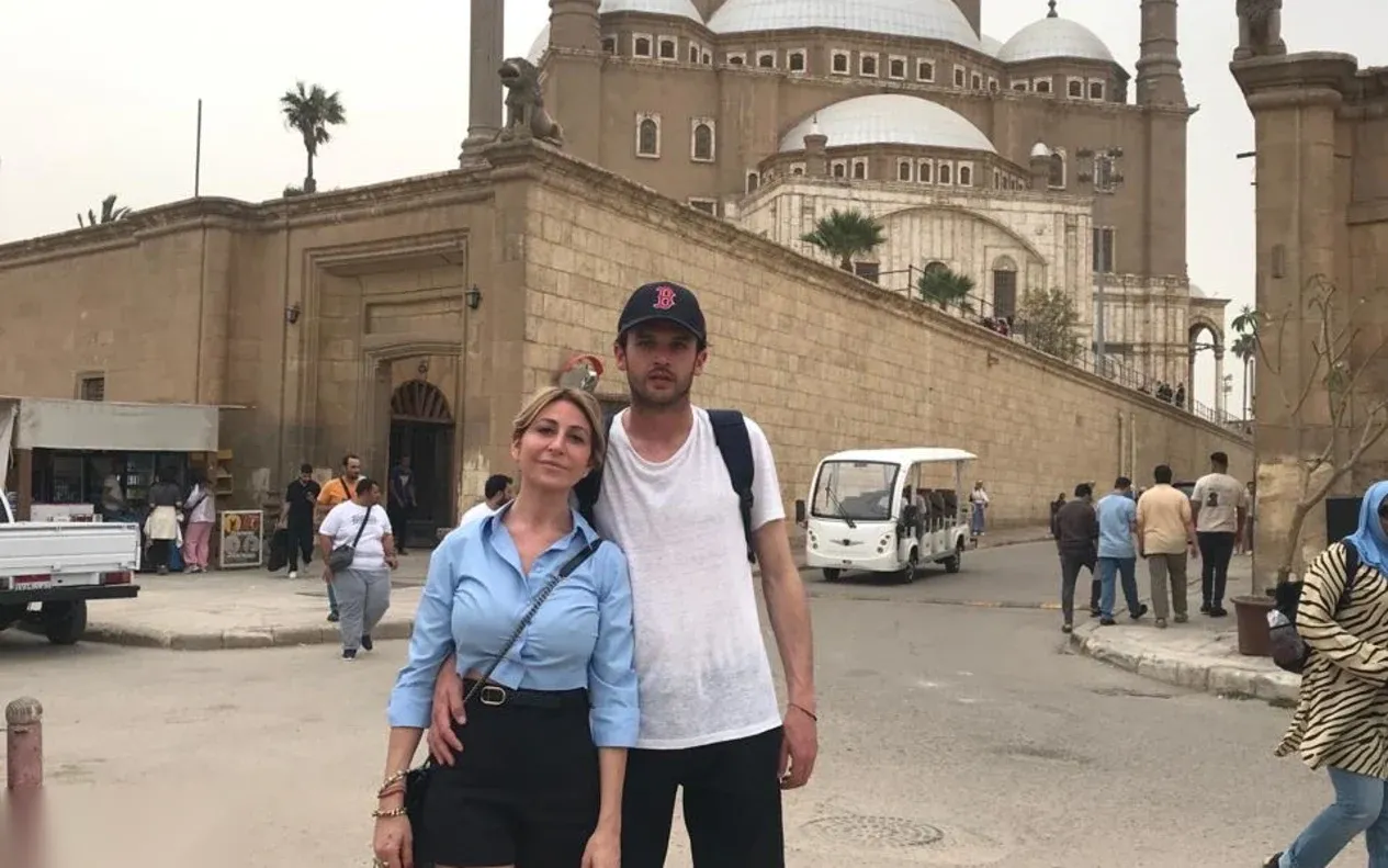 A couple posing together in front of the Mohamed Ali Mosque's domes and minarets at the Cairo Citadel.