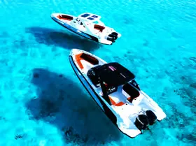 Aerial view of two speedboats anchored side by side over clear turquoise water.