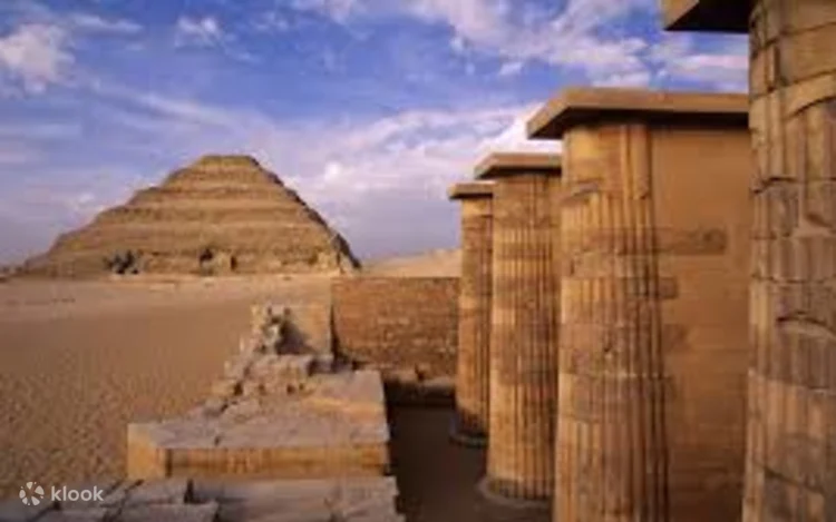 Group of tourists posing together on the sand in front of the Step Pyramid of Djoser at Saqqara
